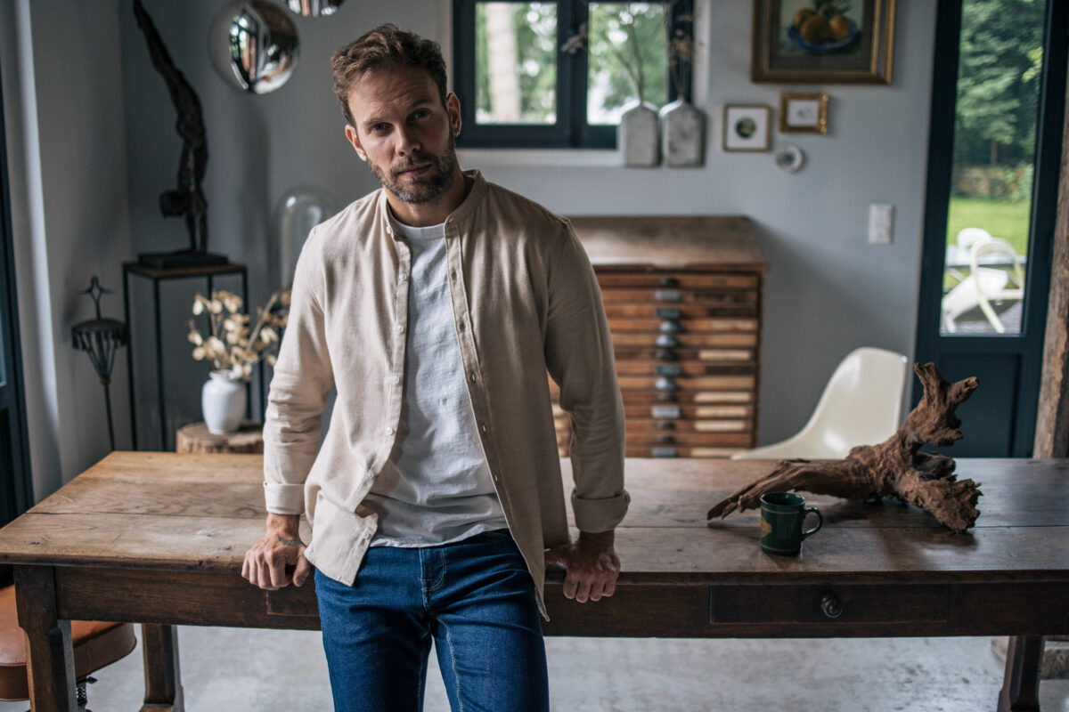 Chemise-beige-homme-debout-maison
