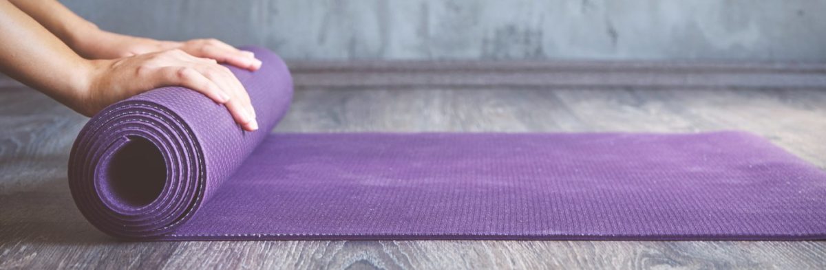 tapis de yoga violet qui est enroulé