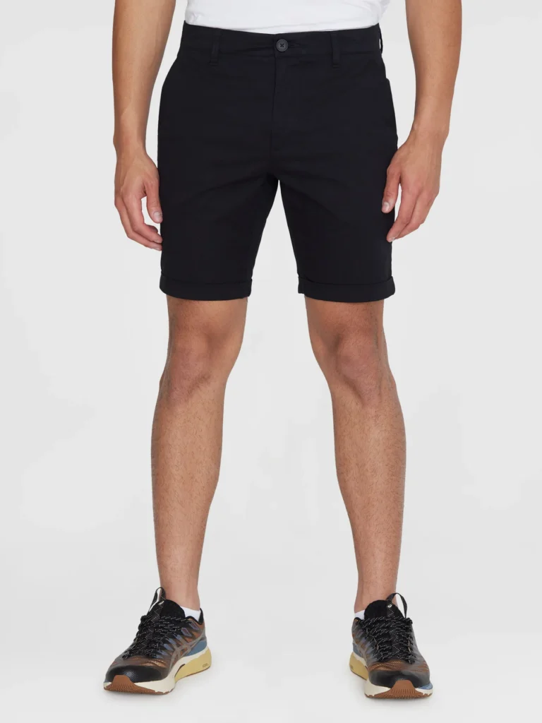 Zoom sur un short noir basique de la marque Knowledge Cotton Apparel, porté par un mannequin