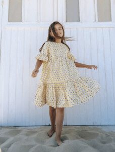 enfant portant une robe colorée jaune