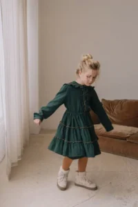 enfant portant une robe vert sapin