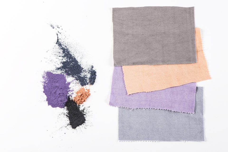 Des tissus de différentes couleurs, beige, violet et gris, réduits en poudre colorante Recycrom.