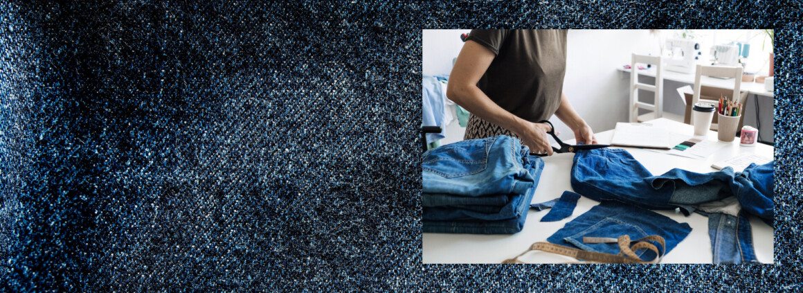 Une couturière travaille sur une toile de denim avec des ciseaux.