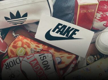 Des produits de mode (sacs, chaussures) dont les logos parodient de fausses marques posés en vrac. On voit notamment un logo NIKE surmonté de la mention FAKE.