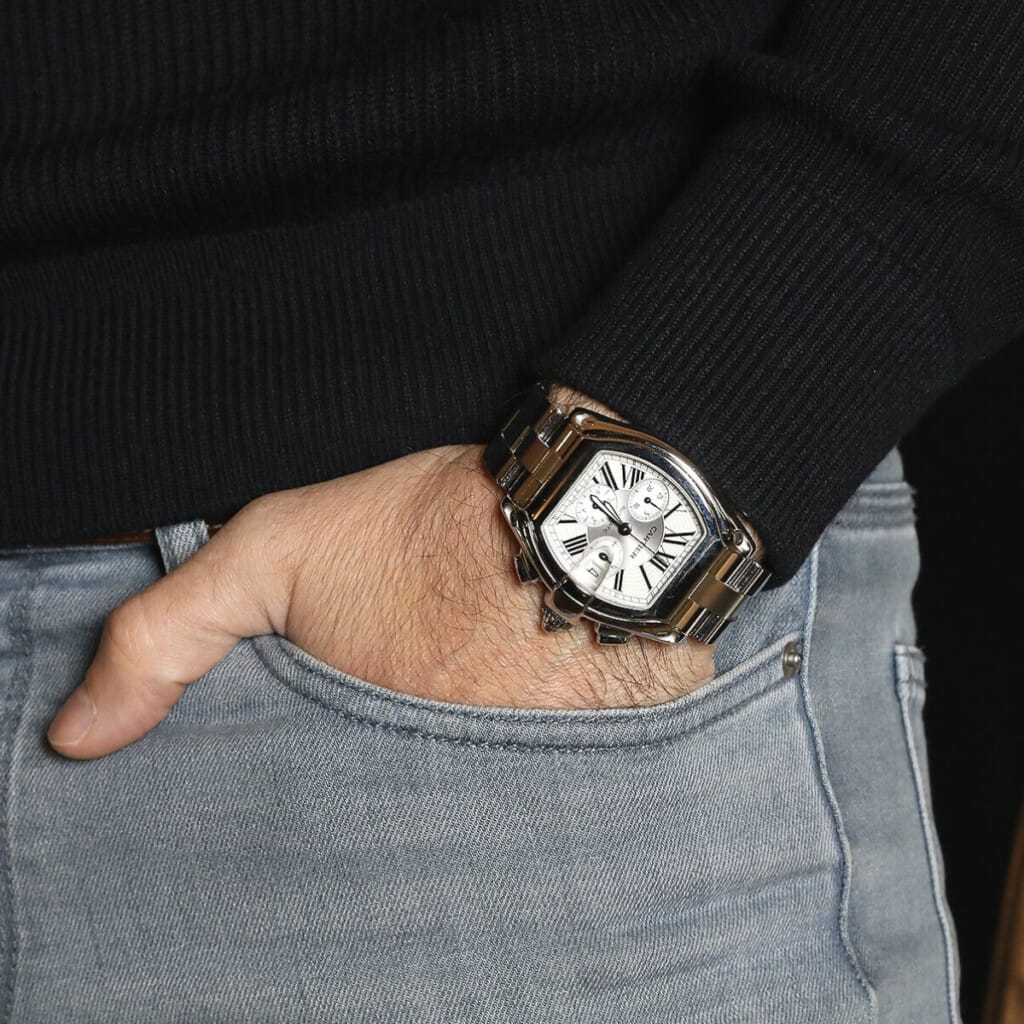 Une main d'homme avec, au poignet, une montre Cartier