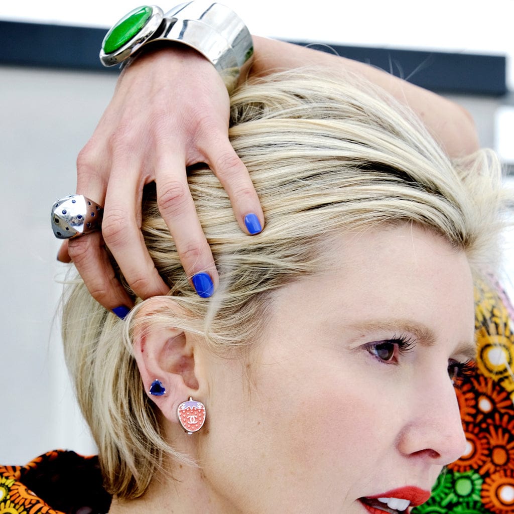 Une mannequin pose avec des bijoux Chanel au poignet, aux oreilles et aux doigts