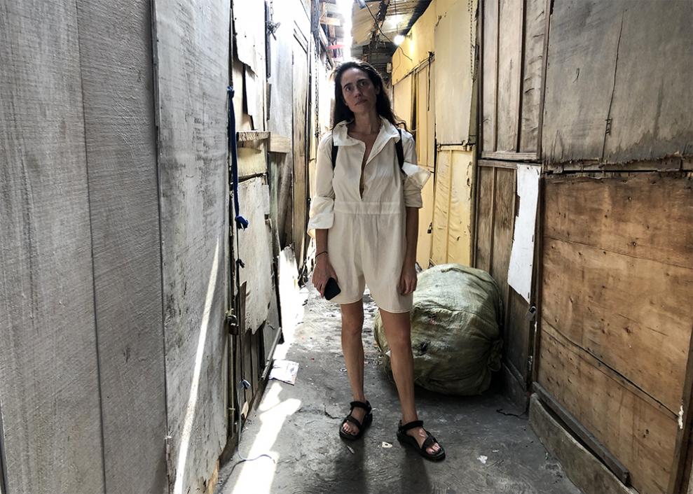 Liz Ricketts se tient debout dans une rue du Ghana au milieu des déchets.