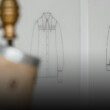 Banniere eco-concetion : un mannequin stockman dans un atelier avec, en fond, des croquis de vêtements
