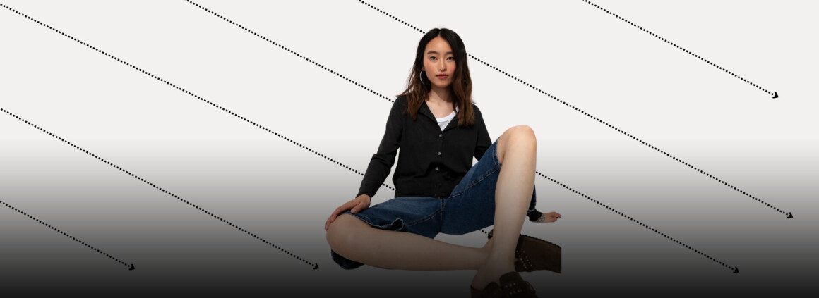 femme-assise-tailleur-jean-pull-noir-fleches