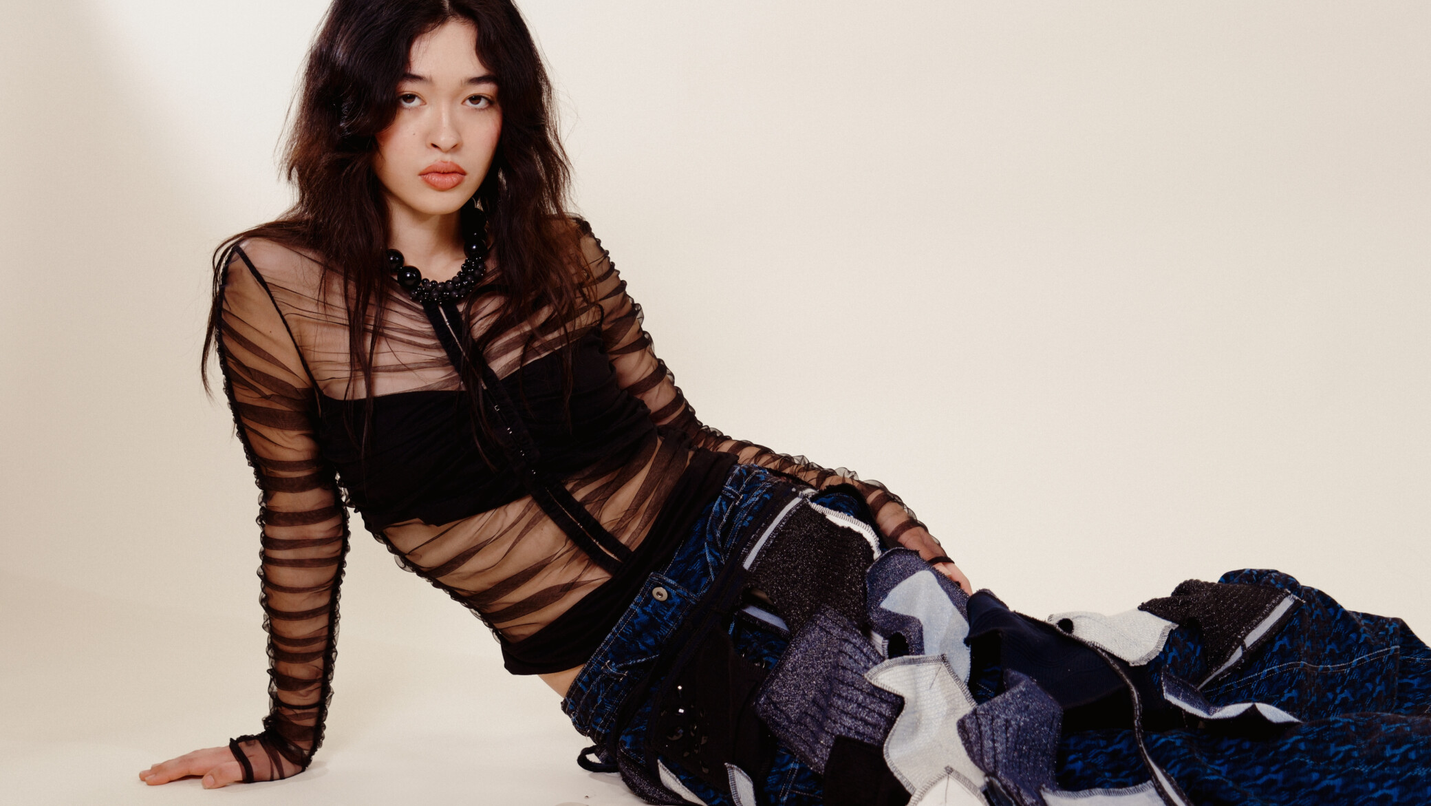 femme assise robe noire jean