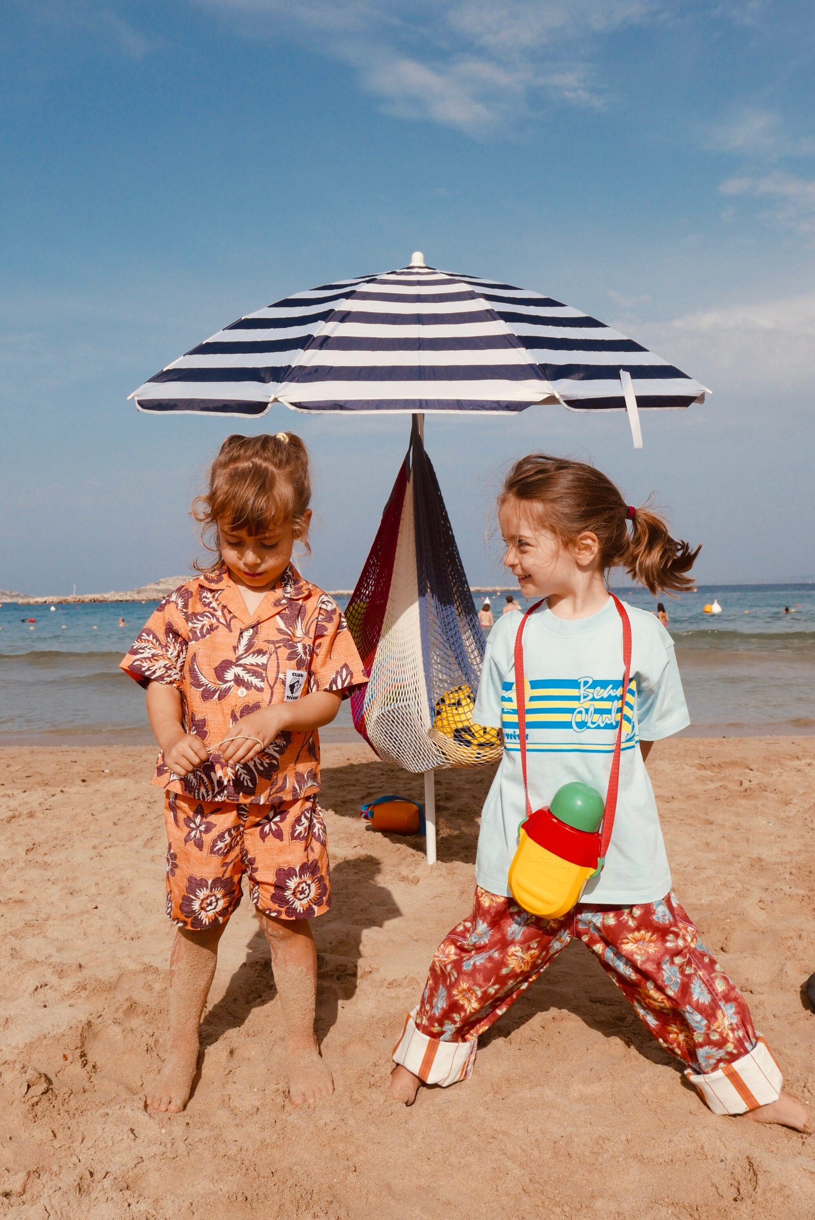 deux-filles-sur-la-plage-avec-des-vêtements-club-trésor