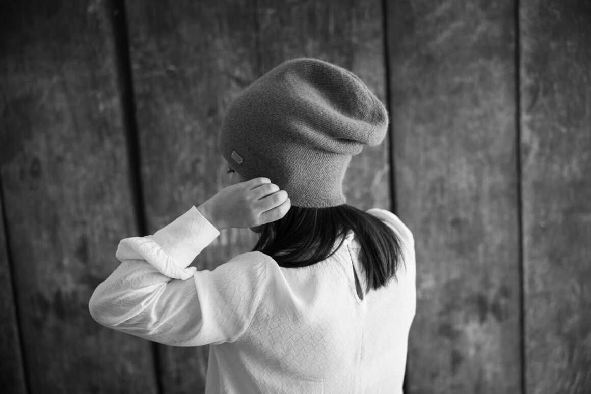petite-fille-de-dos-met-un-bonnet-en-laine