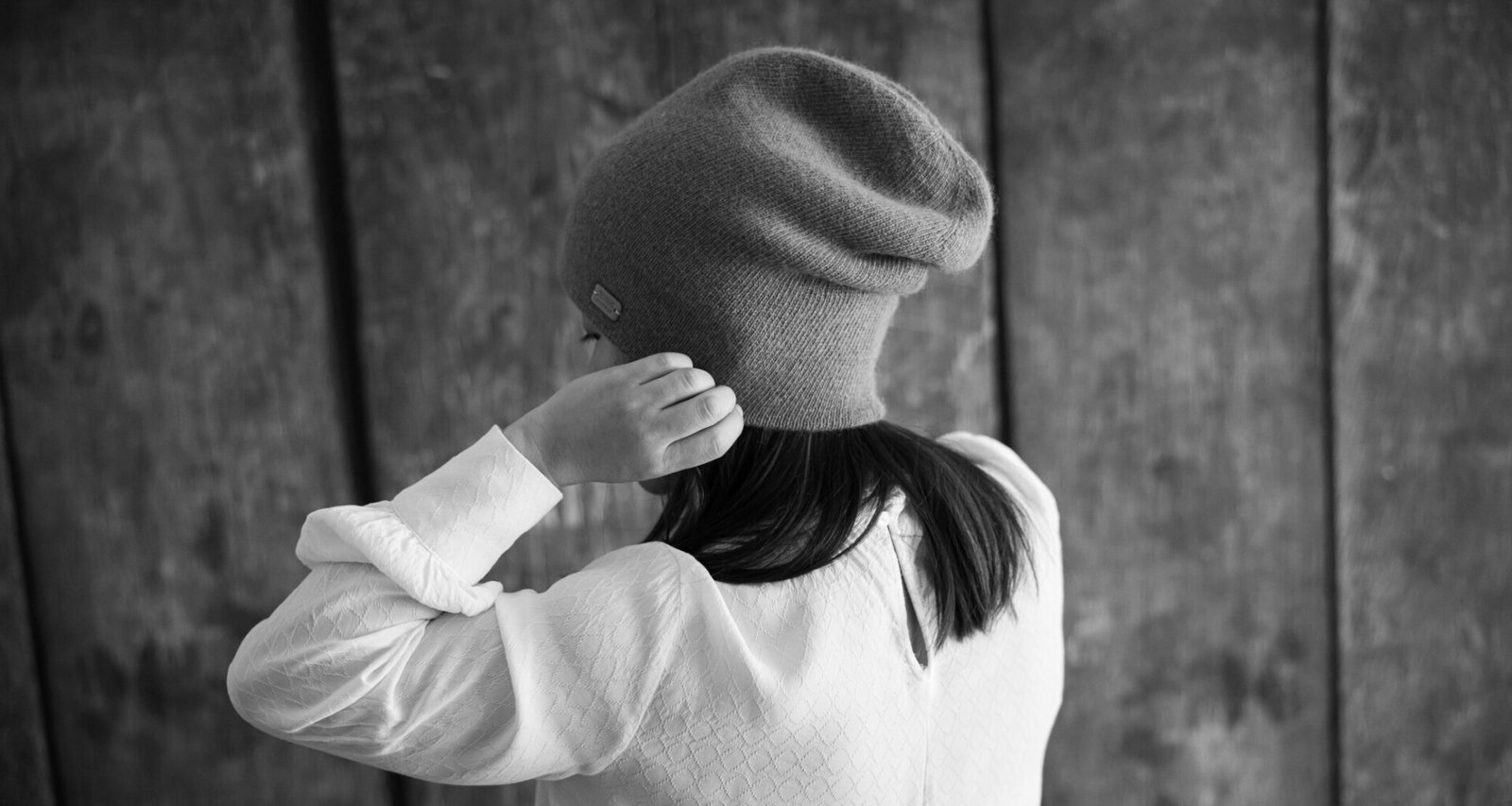 petite-fille-de-dos-met-un-bonnet-en-laine