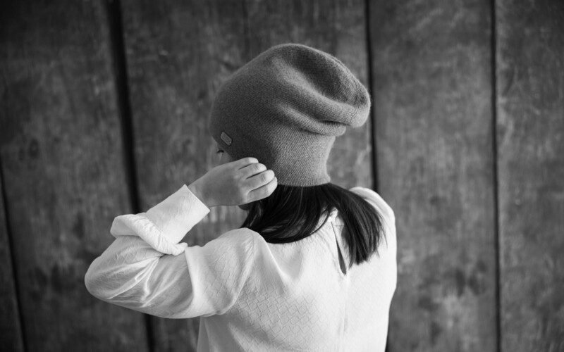 petite-fille-de-dos-met-un-bonnet-en-laine