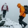 deux-personnes-escaladent-une-montagne-enneigee-habillees-en-arcteryx