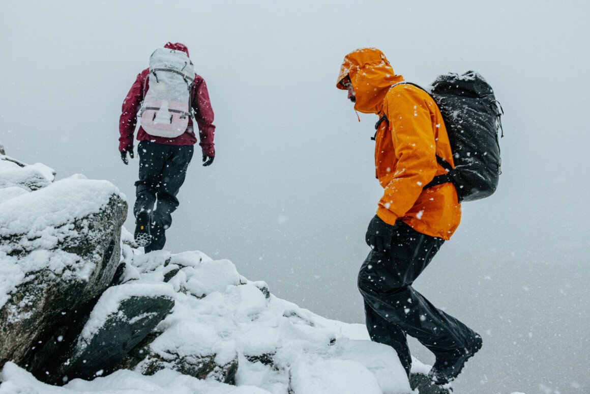 deux-personnes-escaladent-une-montagne-enneigee-habillees-en-arcteryx