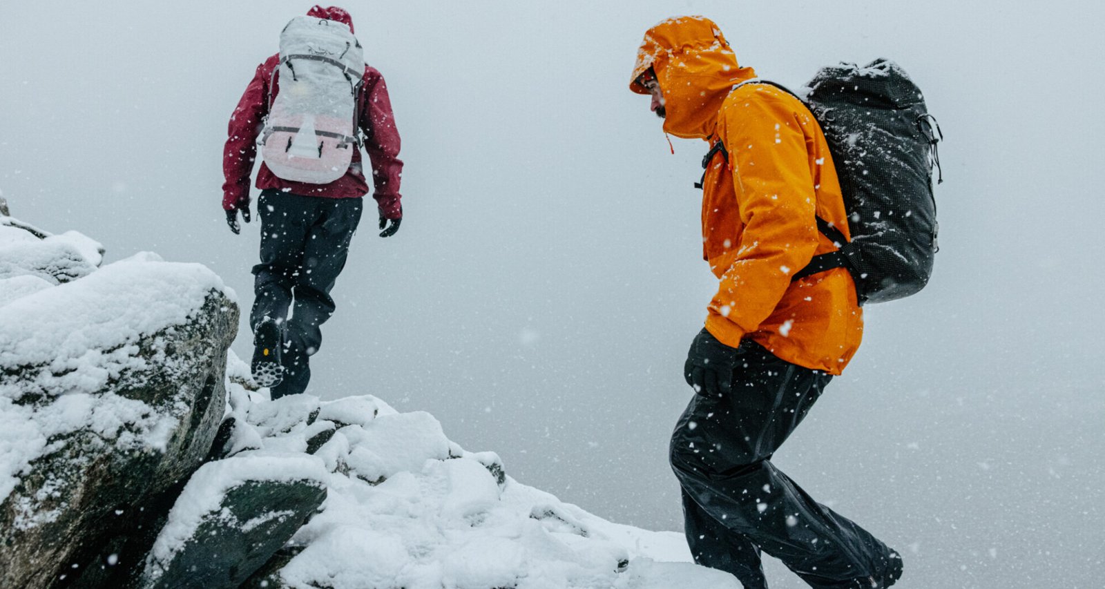 deux-personnes-escaladent-une-montagne-enneigee-habillees-en-arcteryx