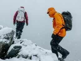 deux-personnes-escaladent-une-montagne-enneigee-habillees-en-arcteryx