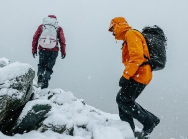 deux-personnes-escaladent-une-montagne-enneigee-habillees-en-arcteryx